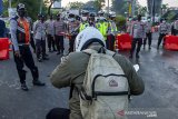 Petugas gabungan menghalau pemudik yang melintas di perbatasan Karawang-Bekasi, Jawa Barat, Minggu (9/5/2021). Korlantas Polri mencatat selama tiga hari dari 381 titik penyekatan larangan mudik, polisi telah memutarbalikkan sekitar 70 ribu lebih kendaraan yang tidak memenuhi persyaratan perjalanan atau terindikasi mudik. ANTARA JABAR/M Ibnu Chazar/agr