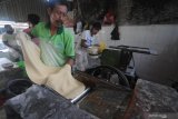 Pekerja membuat adonan kue di Pasar Kolpajung, Pamekasan, Jawa Timur, Minggu (9/5/2021). Dalam dua hari terakhir permintaan adonan kue basah dan kering untuk lebaran meningkat dari 90 kg menjadi 400-500 kg per hari. Antara Jatim/Saiful Bahri/zk