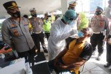 Kapolres Kediri AKBP Lukman Cahyono (kiri) mematau swab test antigen kepada pengguna jalan di perbatasan Kediri, Jawa Timur, Sabtu (8/5/2021). Polisi melakukan tes acak kepada pengguna jalan antar kabupaten pada masa pelarangan mudik 2021. Antara Jatim/Prasetia Fauzani/zk