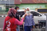 Relawan SIBAT Palang Merah Indonesia (PMI) di Kelurahan Benteng, Jawa Barat, melakukan pengecekan suhu kepada sejumlah warga dan mengingatkan masyarakat akan pentingnya menggunakan masker saat melakukan aktivitas di luar rumah. (Antara/HO/PMI/IFRC).