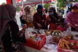 Pelaku Usaha Mikro Kecil Menengah (UMKM) melayani pembeli saat bazar makanan dan minuman Ramadhan 1442 di lapak UMKM Donopuran Kelurahan Taman, Kota Madiun, Jawa Timur, Senin (10/5/2021). Bazar UMKM yang menjual produk makanan dan minuman dengan harga antara Rp5.000 hingga Rp15.000 per kemasan dan diikuti puluhan pelaku UMKM tersebut dimaksudkan untuk membantu UMKM tetap bisa bertahan pada masa pandemi COVID-19. Antara Jatim/Siswowidodo/zk