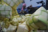  Pedagang membuat cangkang ketupat dagangannya di Pasar 17 Agustus, Pamekasan, Jawa Timur, Selasa (12/5/2021). Cangkang ketupat yang dibuat hanya untuk kebutuhan Idul Fitri 1442 H tersebut dijual Rp5.000 per ikat isi 10 cangkang. Antara Jatim/Saiful Bahri/zk