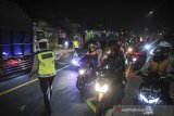 Petugas Kepolisian memutarbalikan kendaraan roda dua di posko penyakatan mudik Limbangan, Kabupaten Garut, Jawa Barat, Selasa (11/5/2021). Pada H-2 Idul Fitri 1442 H, petugas di posko penyekatan mudik Limbangan memutarbalikan ratusan pengendara roda dua yang hendak mudik ke arah Tasikmalaya, Ciamis dan Jawa Tengah. ANTARA JABAR/Raisan Al Farisi/agr