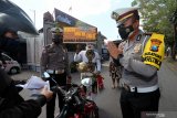  Kasatlantas Polres Blitar AKP Putu Angga Feriyana (Kanan) memeriksa berkas perjalanan pengendara yang melintas saat penyekatan di pos penyekatan arus mudik di jalan lintas Blitar-Malang, Jawa Timur, Selasa (11/5/2021). Penempatan petugas berkostum wayang tersebut guna mensosialisasikan kepada masyarakat agar tidak mudik dengan cara yang lebih humanis, sehingga diharapkan mampu meningkatkan kesadaran masyarakat. Antara Jatim/Irfan Anshori/zk