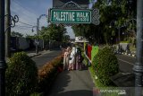 Warga berswafoto di Pedestrian Palestine Walk kawasan Asia Afrika, Bandung, Jawa Barat, Kamis (13/5/2021).  Warga Kota Bandung menikmati suasana sepi di sejumlah titik wisata kota usai melaksanakan Shalat Ied 1442 Hijriah. ANTARA JABAR/Novrian Arbi/agr