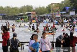 Pengunjung menikmati suasana liburan di pantai Karangsong, Indramayu, Jawa Barat, Jumat (14/5/2021). Obyek wisata pantai Karangsong ramai dikunjungi warga pada hari kedua Lebaran meskipun ada larangan membuka tempat wisata oleh Pemda setempat. ANTARA JABAR/Dedhez Anggara/agr