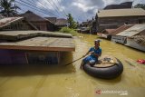 Seorang warga menggunakan ban karet melintasi banjir yang merendam permukiman di Jalan Biduri, Kecamatan Satui, Kabupaten Tanah Bumbu , Kalimantan Selatan, Sabtu (15/5/2021). BPBD Kabupaten Tanah Bumbu mencatat sebanyak 2.126 unit rumah di Kecamatan Satui tersebut terendam banjir setinggi 50 cm hingga dua meter akibat tingginya intensitas curah hujan yang mengakibatkan meluapnya Sungai Satui. Foto Antaranews Kalsel/Bayu Pratama S.