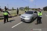 Petugas Kepolisian Polresta Cirebon menghentikan kendaraan yang melintas untuk dilakukan pemeriksaan kelengkapan dokumen di jalur Pantura Susukan, Kabupaten, Cirebon, Jawa Barat, Sabtu (15/5/2021). Pemeriksaan kelengkapan dokumen tersebut untuk memastikan kendaraan dengan plat nomor di luar Cirebon yang akan menuju Jakarta sudah dilengkapi dengan surat keterangan bebas COVID-19. ANTARA JABAR/Dedhez Anggara/agr