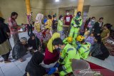 Petugas kesehatan dari emergency response team PT. Putra Perkasa Abadi memberikan pelayanan kesehatan kepada warga korban banjir yang mengungsi di Gedung Majelis Ta'Lim Desa Sungai Danau, Kabupaten Tanah Bumbu, Kalimantan Selatan, Sabtu (15/5/2021). Petugas medis di Posko Kesehatan mencatat pengungsi yang memeriksakan diri sebagian besar mengeluhkan pusing dan diare akibat banjir. Foto Antaranews Kalsel/Bayu Pratama S.