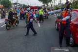 Petugas gabungan menghalau pemudik sepeda motor saat penyekatan arus balik mudik di Desa Balonggandu, Jatisari, Karawang, Jawa Barat, Minggu (16/5/2021). Penyekatan transportasi tersebut mengarahkan pemudik motor untuk melakukan rapid test swab antigen guna meminimalisir kasus penyebaran COVID-19 setelah Lebaran. ANTARA JABAR/M Ibnu Chazar/agr