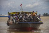 Warga menggunakan kapal feri tradisional Banjarmasin-Barito Kuala dari Dermaga Banjar Raya, Banjarmasin, Kalimantan Selatan, Senin (17/5/2021). Menurut pihak pengelola kapal motor, arus balik dari Banjarmasin menuju sejumlah daerah pelosok di Kalsel-Kalteng melalui jalur sungai mulai meningkat setelah dibukanya dermaga penyeberangan pascapenutupan selama enam hari saat Lebaran. Foto Antaranews Kalsel/Bayu Pratama S.