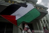 Massa yang tergabung dalam Aliansi Umat Islam Jabar mengibarkan bendera Palestina saat aksi di Gedung Merdeka , Bandung, Jawa Barat, Selasa (18/5/2021). Aksi tersebut untuk mengutuk dan mengecam atas penyerangan brutal Israel ke Palestina hingga saat ini dan meminta pemerintah Indonesia terus memberikan dukungan tanpa henti ke Palestina. ANTARA JABAR/Novrian Arbi/agr