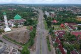 Foto udara suasana kendaraan saat melintasi Jalan Lintas Tengah Sumatera di Pasir Putih, Bungo, Jambi, Selasa (18/5/2021). Lalu lintas kendaraan di jalan penghubung Jambi dengan Sumatera Barat tersebut terpantau normal, sementara sejumlah pemudik terpantau melintas bebas di tengah tidak maksimalnya penyekatan oleh petugas. ANTARA FOTO/Wahdi Septiawan/foc.