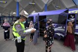 Polisi memeriksa surat keterangan sehat bebas COVID-19 milik penumpang minibus saat pengetatan arus balik Lebaran di Terminal Tipe A Mengwi, Badung, Bali, Selasa (18/5/2021). Kegiatan yang digelar pada 18-24 Mei 2021 tersebut menyasar minibus, bus dan mobil pribadi berplat luar Bali dengan memeriksa surat izin jalan kendaraan dan surat keterangan sehat bebas COVID-19. ANTARA FOTO/Nyoman Hendra Wibowo/nym.