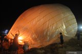  Warga bersiap menerbangkan balon asap di Desa Blumbungan, Pamekasan, Jawa Timur, Rabu (19/5/2021). Tradisi menerbangkan balon asap dilakukan warga di daerah itu guna memeriahkan lebaran ketupat. Antara Jatim/Saiful Bahri/zk