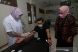 Ketua DPD Partai Golkar Provinsi Kalbar sekaligus Anggota Komisi VII DPR Maman Abdurrahman (tengah) didampingi Direktur RSUD dr Soedarso Pontianak drg Yuliastuti Saripawan (kanan) saat menjalani pengambilan sampel darah penyintas COVID-19 untuk seleksi awal donor plasma konvalesen di RSUD dr Soedarso, Pontianak, Kalimantan Barat, Kamis (20/5/2021). Pengambilan sampel darah untuk ‘screening’ atau pemeriksaan titer antibodi COVID-19 itu dilakukan Maman Abdurrahman sebelum melakukan donor plasma konvalesen untuk menambah stok plasma guna membantu pasien COVID-19 dengan gejala berat. ANTARA FOTO/Jessica Helena Wuysang