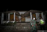 Personel TNI dan POLRI mengecek konidisi rumah warga yang mengalami kerusakan di Desa Ploso Kecamatan Selopuro, Blitar, Jawa Timur, Jumat (21/5/2021) malam.  BPBD setempat masih mendata sejumlah kerusakan bangunan akibat gempa 6,2 magnitudo yang terjadi sekitar pukul 19.09 WIB dan berpusat di lepas pantai selatan blitar tersebut. Antara Jatim/Irfan Anshori/zk