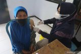 Petugas kesehatan menyuntikkan vaksin COVID-19 kepada warga di Balai Desa Sitimerto, Kediri, Jawa Timur, Sabtu (22/5/2021). Pemberian vaksin untuk lansia dan pekerja publik dilakukan di sejumlah balai desa dari sebelumnya hanya diberikan di puskesmas atau tingkat kecamatan untuk mempermudah layanan guna meningkatkan cakupan vaksinasi COVID-19 di tingkat desa. Antara Jatim/Prasetia Fauzani/zk