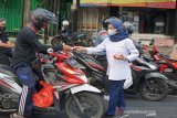 Relawan PMI Sidorajo, Jawa Timur, bagikan masker wajah beserta perangkat kebersihan lainnya yang mendukung Perilaku Hidup Bersih dan Sehat (PHBS) di jalan raya. (Antara/HO/PMI/IFRC).