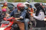Relawan PMI Sidorajo, Jawa Timur, bagikan masker wajah beserta perangkat kebersihan lainnya yang mendukung Perilaku Hidup Bersih dan Sehat (PHBS) di jalan raya. (Antara/HO/PMI/IFRC).
