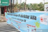 Relawan PMI Sidorajo, Jawa Timur, bentangkan spanduk sosialisasikan protokol kesehatan demi memutus rantai penyebaran COVID-19 di jalan raya.(Antara/HO/PMI/IFRC).