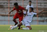 Pemain tim sepak bola PON Jawa Timur Afiludin (kanan) mencoba menghalau pesepak bola Persipura Joshua Isir (kiri) saat pertandingan uji coba di Stadion Gelora Sepuluh Nopember di Surabaya, Jawa Timur, Sabtu (22/5/2021). Laga uji coba tersebut berakhir dengan skor 0-0. Antara Jatim/Moch Asim/zk.