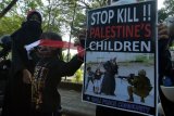 Massa yang tergabung dalam ormas Ahlulbait Indonesia (ABI) wilayah Bali membawa poster seruan saat aksi solidaritas dan penolakan agresi Israel terhadap Palestina di Denpasar, Bali, Senin (24/5/2021). Aksi tersebut untuk solidaritas kemanusiaan dari ABI Bali sekaligus memberikan edukasi kepada masyarakat tentang keadaan yang terjadi di Palestina. ANTARA FOTO/Nyoman Hendra Wibowo/nym.