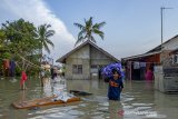 Warga menyelamatkan barang miliknya saat banjir di Desa Karangligar, Karawang, Jawa Barat, Selasa (25/5/2021). Banjir yang melanda di wilayah itu disebabkan meluapnya air sungai Cibeet karena tingginya intensitas hujan dan mengakibatkan ratusan rumah terendam banjir. ANTARA JABAR/M Ibnu Chazar/agr