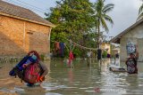 Warga menyelamatkan barang miliknya saat banjir di Desa Karangligar, Karawang, Jawa Barat, Selasa (25/5/2021). Banjir yang melanda di wilayah itu disebabkan meluapnya air sungai Cibeet karena tingginya intensitas hujan dan mengakibatkan ratusan rumah terendam banjir. ANTARA JABAR/M Ibnu Chazar/agr