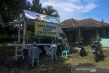 Warga mengurus surat keterangan tidak masuk kerja di mobil pelayanan keliling Pemerintah Desa Dayeuhkolot di Kampung Bojongasih, Kabupaten Bandung, Jawa Barat, Selasa (25/5/2021). Pemerintah Desa Dayeuhkolot berinisiatif untuk memindahkan pelayanan publik dengan menggunakan mobil pelayanan keliling akibat kantor desa yang terendam banjir. ANTARA JABAR/Raisan Al Farisi/agr