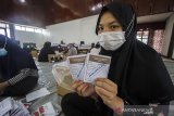 Petugas menunjukkan surat suara pemilihan ulang Gubernur dan Wakil Gubernur Kalimantan Selatan di Gedung Wanita, Banjarmasin, Kalimantan Selatan, Rabu (26/5/2021). KPU Provinsi Kalsel telah mendistribusikan Sebanyak 273.543 lembar surat suara pemilihan ulang Gubernur dan Wakil Gubernur Kalsel ke wilayah yang menggelar pemungutan suara ulang (PSU) pascaputusan Mahkamah Konstitusi (MK) yang akan di selenggarakan pada 9 Juni 2021 nanti di tujuh kecamatan dari tiga Kabupaten/Kota di Provinsi Kalimantan Selatan. Foto Antaranews Kalsel/Bayu Pratama S.