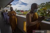 Bhikkhu Saddhaviro Mahathera (kanan) diikuti umat Buddha melakukan prosesi Pradaksina di Vihara Dhammasoka, Banjarmasin, Kalimantan Selatan, Rabu (26/5/2021). Pelaksanaan rangkaian hingga puncak upacara Tri Suci Waisak 2021 di vihara tersebut disiarkan secara online dan terbatas dengan menerapkan protokol kesehatan secara ketat untuk mencegah penyebaran COVID-19. Foto Antaranews Kalsel/Bayu Pratama S.