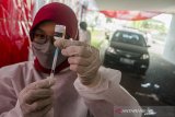 Petugas tenaga kesehatan menyiapkan vaksin COVID-19 untuk disuntikkan pada layanan Vaksinasi Drive Thru Gojek dan Halodoc di Monumen Perjuangan Rakyat Jawa Barat, Bandung, Jawa Barat, Kamis (27/5/2021). Pemerintah Jawa Barat menargetkan sedikitnya 5000 lansia dan 5000 mitra gojek bisa terfasilitasi dalam vaksinasi selama 30 hari kedepan sehingga mempercepat target terbentuknyaherd Immunity bagi warga Jawa Barat. ANTARA JABAR/Novrian Arbi/agr