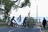 Muhammad Maahir (kedua kiri) bersama Achmad Hairudin tiba di Banyuwangi setelah menempuh perjalanan Jakarta-Banyuwangi untuk menggalang dana donasi Palestina di Watudodol, Banyuwangi, Jawa Timur, Kamis (27/5/2021). Bersepeda start dari Jakarta dan finish di Banyuwangi sejauh 1.130 kilometer itu, sebagai aksi galang dana yang bekerja sama dengan lembaga penyalur bantuan ACT untuk donasi rakyat Palestina.  Hingga saat ini aksi tersebut sudah terkumpul Rp34 juta dari target Rp100 juta. Antara Jatim/Budi Candra Setya/zk