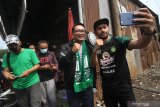 Gubernur Jawa Barat Ridwan Kamil (kedua kanan) menanggapi permintaan swafoto salah satu perwakilan dari suporter Persebaya (Bonek) saat berkunjung ke Surabaya, Jawa Timur, Minggu (30/5/2021). Kunjungan Ridwan Kamil tersebut untuk menjalin silaturahmi dan komunikasi yang diharapkan dapat mempererat lagi persaudaraan antara suporter Persebaya (Bonek) dan suporter Persib (Bobotoh). Antara Jatim/Moch Asim/zk