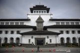 Seorang wartawan melintas di halaman Gedung Sate, Bandung, Jawa Barat, Kamis (3/6/2021). Gedung Sate yang menjadi pusat pemerintahan Provinsi Jawa Barat kembali ditutup hingga 9 Juni 2021 setelah 31 orang ASN dinyatakan terpapar COVID-19 dari hasil tes massal beberapa waktu lalu. ANTARA JABAR/Raisan Al Farisi/agr