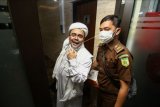 Terdakwa Rizieq Shihab (kiri) memasuki gedung Bareskrim Polri usai menjalani sidang tuntutan di Jakarta, Kamis (3/6/2021). Pada sidang tersebut JPU menuntut Rizieq Shihab pidana penjara selama enam tahun untuk kasus tes usap RS UMMI, Bogor. ANTARA FOTO/Rivan Awal Lingga/nym.