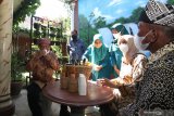 Menteri Dalam Negeri Tito Karnavian (kiri) minum jamu produksi UMKM didampingi Bupati Banyuwangi Ipuk Fiestiandani Azwar Anas(kedua kanan) di Desa Sukojati, Blimbingsari, Banyuwangi, Jawa Timur, Jumat (4/6/2021). Kunjungan kerja Mendagri ke Banyuwangi tersebut untuk meninjau pelayanan publik program smart kampung Desa Sukojati yang akan dijadikan percontohan nasional. Antara Jatim/Budi Candra Setya/zk