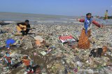 Pendongeng sekaligus seniman tutur Samsudin (kanan) melakukan aksi teatrikal dengan latar belakang tumpukan sampah plastik di pantai Dadap, Juntinyuat, Indramayu, Jawa Barat, Sabtu (6/5/2021). Aksi teatrikal dalam rangka memperingati hari Lingkungan Hidup Sedunia itu untuk mengkritisi pengelolaan sampah plastik di Indonesia. ANTARA JABAR/Dedhez Anggara/agr