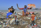 Pendongeng sekaligus seniman tutur Samsudin (kanan) melakukan aksi teatrikal dengan latar belakang tumpukan sampah plastik di pantai Dadap, Juntinyuat, Indramayu, Jawa Barat, Sabtu (6/5/2021). Aksi teatrikal dalam rangka memperingati hari Lingkungan Hidup Sedunia itu untuk mengkritisi pengelolaan sampah plastik di Indonesia. ANTARA JABAR/Dedhez Anggara/agr