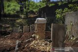 Sebuah kopiah berada di pandu makam jenazah yang terkonfirmasi COVID-19 di TPU Cikadut, Bandung, Jawa Barat, Senin (7/6/2021). Data pusat informasi COVID-19 Kota Bandung mencatat, per tanggal 6 Juni 2021 total kasus terkonfirmasi sebanyak 20.003 kasus dengan jumlah aktif 756 kasus, 18.892 sembuh dan 355 meninggal dunia. ANTARA JABAR/Raisan Al Farisi/agr