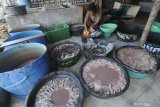 Seorang ibu menyiapkan ikan untuk dikeringkan di Desa Branta Pesisir,  Pamekasan, Jawa Timur, Selasa (8/6/2021). Dalam sebulan terakhir produksi ikan kering di daerah itu turun dari 0.8-2.1 ton menjadi 100-200 kg per hari, karena minimnya tangkapan nelayan akibat cuaca. Antara Jatim/Saiful Bahri/zk