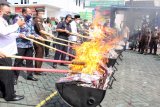 Bupati Sidoarjo Ahmad Muhdlor (kelima kiri) beserta sejumlah petugas memusnahkan barang bukti rokok tanpa cukai di halaman Kantor Kejaksaan Negeri Sidoarjo, Jawa Timur, Rabu (9/6/2021). Kejaksaan Negeri (Kejari) Sidoarjo memusnahkan barang bukti perkara tindak pidana umum dan tindak pidana khusus yang telah memiliki kekuatan hukum tetap berdasarkan putusan pengadilan berupa sabu seberat 30,9 kg, ganja 3,3 kg, pil dobel L sebanyak 124.927 butir, ekstasi 1.045 butir, tembakau gorilla 3,2 kg serta serta ribuan batang rokok ilegal. Antara Jatim/Umarul Faruq/zk