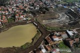 Foto udara proyek pembangunan Kolam Retensi Andir di Kabupaten Bandung, Jawa Barat, Rabu (9/6/2021). Proyek pembangunan kolam retensi di lahan seluas 4,85 hektare yang dapat menampung air hingga 137.500 meter kubik tersebut ditujukan untuk menanggulangi banjir luapan Sungai Citarum serta ditargetkan akan rampung pada Desember 2021 mendatang. ANTARA JABAR/Raisan Al Farisi/agr