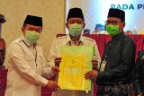 Ketua KPU Provinsi Jambi Subhan (kanan) menyerahkan dokumen hasil rapat kepada Pasangan Calon Gubernur dan Wakil Gubernur Terpilih Al Haris (kiri) dan Abdullah Sani (tengah) saat Rapat Pleno Terbuka Penetapan Pasangan Calon Gubernur dan Wakil Gubernur Terpilih pada Pemilihan Gubernur dan Wakil Gubernur Jambi Tahun 2020, di Jambi, Sabtu (12/6/2021). KPU setempat menetapkan pasangan Al Haris - Abdullah Sani sebagai Gubernur dan Wakil Gubernur Jambi terpilih dengan perolehan suara 600.733 suara, mengungguli pasangan Cek Endra - Ratu Munawaroh dengan 587.918 suara, dan pasangan Fachrori Umar - Syafril Nursal dengan 381.634 suara. ANTARA FOTO/Wahdi Septiawan/hp.