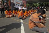 Polisi menghadirkan tersangka saat ungkap kasus premanisme di Polda Jawa Timur, Surabaya, Jawa Timur, Senin (14/6/2021). Ditreskrimum Polda Jawa Timur bersama Polresta Sidoarjo, Polres Pelabuhan Tanjung Perak, Polres Mojokerto dan Polres Gresik menangkap 67 tersangka kasus dugaan premanisme dengan mengamankan sejumlah barang bukti beberapa diantaranya 69 bendel karcis pungutan liar, senjata tajam dan uang tunai Rp9.597.000. Antara Jatim/Didik Suhartono/zk