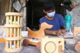 Perajin membuat mainan edukasi dari kayu untuk dikirim ke Jakarta di rumah produksi Dolan Kayu, Malang, Jawa Timur, Selasa (15/6/2021). Perajin mainan edukasi kayu setempat mengeluhkan monopoli bahan baku berupa kayu pinus yang dilakukan sejumlah oknum distributor dan membuat harganya naik dari Rp90.000 menjadi 120 ribu rupiah per ikat sehingga biaya produksi makin membengkak. Antara Jatim/Ari Bowo Sucipto/zk