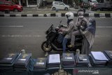 Seorang guru memberikan rapor kepada orang tua siswa saat penerimaan rapor dengan layanan tanpa turun di SD Darul Hikam, Bandung, Jawa Barat, Selasa (15/6/2021). Sebanyak 500 siswa tingkat SD Darul Hikam mengikuti pembagian rapor dengan layanan tanpa turun guna mencegah kerumunan di tengah pandemi COVID-19. ANTARA JABAR/Raisan Al Farisi/agr