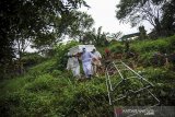 Tenaga pikul membawa jenazah dengan protokol COVID-19 untuk dimakamkan di TPU Cikadut, Bandung, Jawa Barat, Selasa (15/6/2021). Petugas pikul jenazah mengatakan, pemakaman jenazah dengan protokol COVID-19 di TPU Cikadut mengalami peningkatan sebanyak 20 hingga 30 jenazah per hari dibandingkan dengan bulan lalu yang hanya lima hingga delapan jenazah per hari. ANTARA JABAR/Raisan Al Farisi/agr