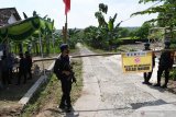  Personel Korps Brimob dari Mabes Polri melakukan pengamanan wilayah di Desa Bantengan, Wungu, Kabupaten Madiun, Jawa Timur, Selasa (15/6/2021). Mabes Polri menugaskan 25 personel Korps Brimob ke wilayah tersebut guna membantu pengamanan dan percepatan penanganan COVID-19 setelah adanya 88 warga dinyatakan positif COVID-19 dari klaster hajatan pernikahan, sehingga akses masuk maupun keluar wilayah dua RT ditutup. Antara Jatim/Siswowidodo/zk